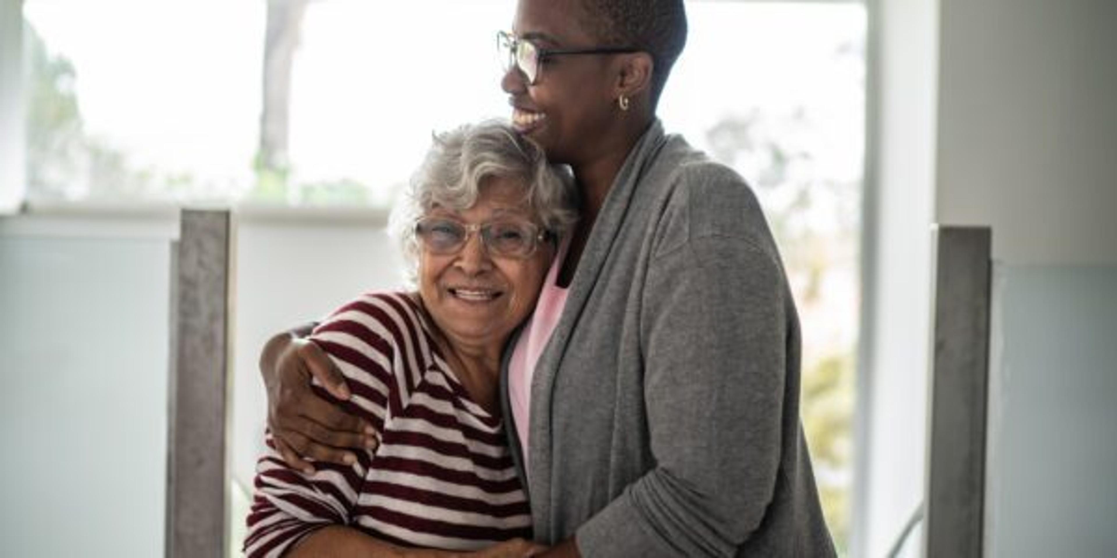 Caregiver hugging older woman